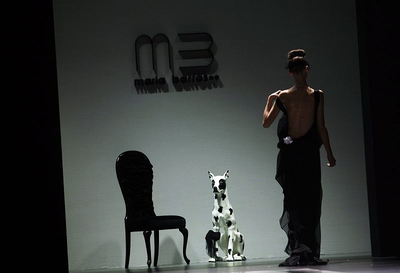 A model adjusts an outfit by designer Barros during the Cibeles Madrid Fashion Week Fall/Winter 2010 show in Madrid