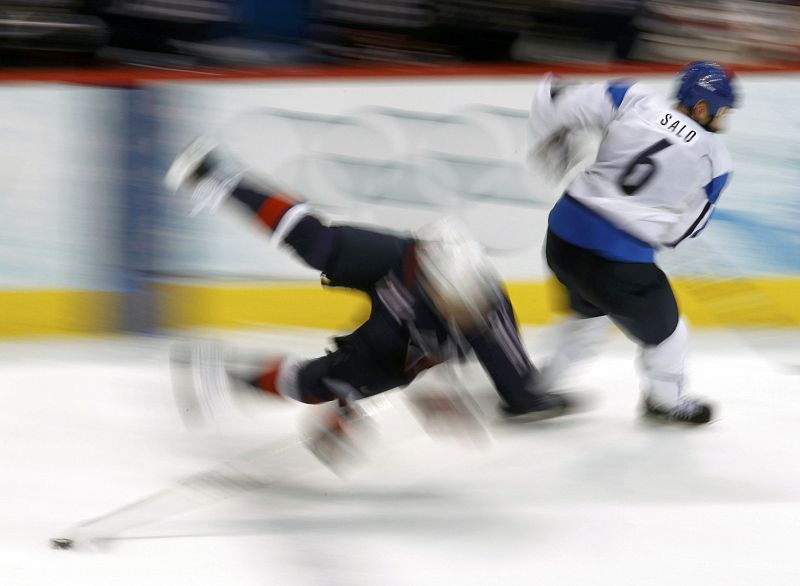 Finland's Sami Salo collides with a U.S. hockey player during their men's ice hockey playoff semifinals game at the Vancouver 2010 Winter Olympics