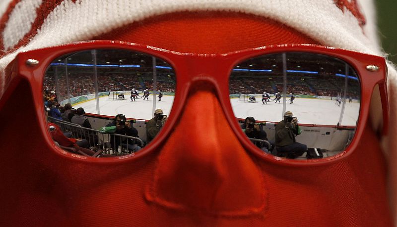 A spectator watches play during the men's play-offs semifinals hockey game between Finland and the U.S. at the Vancouver 2010 Winter Olympics