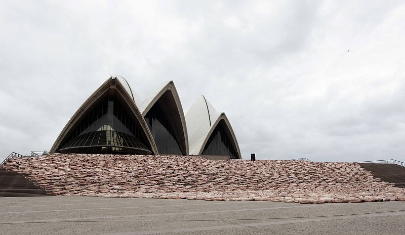 La concha de la Ópera de Sydney parece flotar sobre la base de los cuerpos desnudos