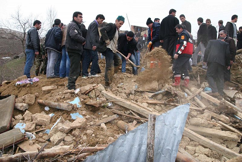 Varias personas buscan entre los escombros de una vivienda en Okcular, Turquía, después del  terremoto de 6 grados de magnitud