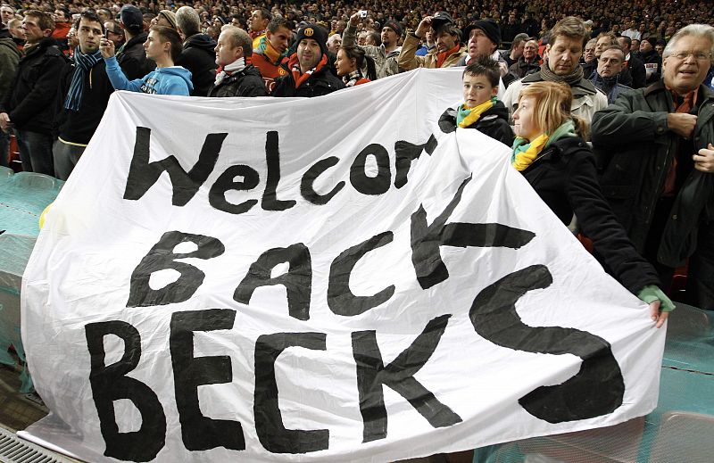 Manchester United fans hold a banner for former player Beckham before their Champions League match against AC Milan at Old Trafford in Manchester
