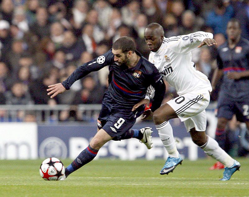 El centrocampista francés del Real Madrid Lassana Diarra pelea por el control del balón con el delantero argentino del Olympique de Lyon, Lisandro López.