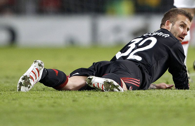 AC Milan's Beckham lies on the pitch during their Champions League match against Manchester United at Old Trafford in Manchester