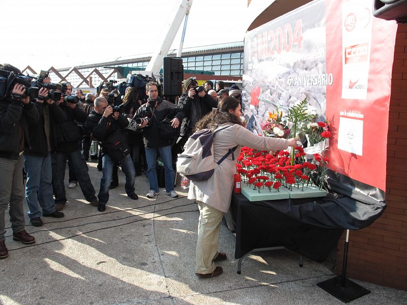 Una chica coloca en Atocha sus flores de homenaje a las víctimas