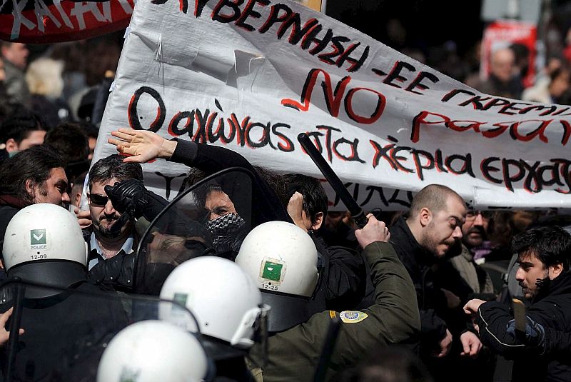 Manifestantes se enfrentan con los policías antidisturbio.