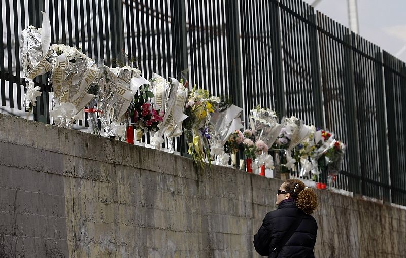 Una mujer observa los ramos de flores colocados en recuerdo de las víctimas del 11M en la calle Téllez