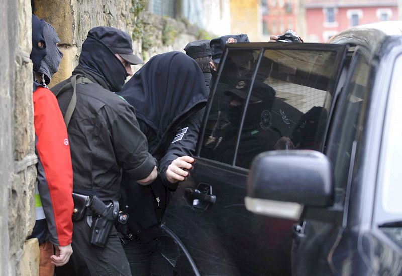 Agentes de la Ertzaintza introducen en un vehículo al hombre detenido en Algorta, País Vasco.