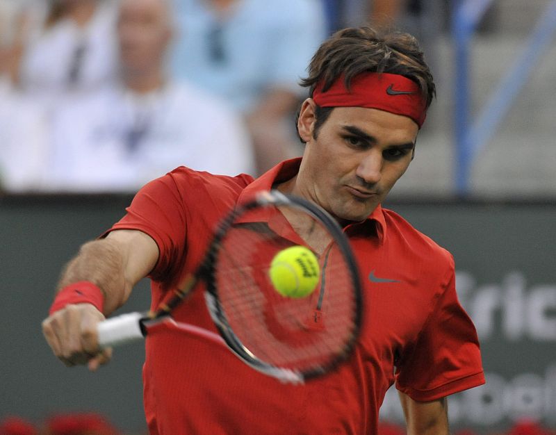 El tenista suizo Roger Federer devuelve la pelota ante el rumano Victor Hanescu.