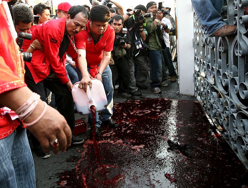 Un manifestante vierte una garrafa llena de sangre durante las manifestación de este martes en Tailandia