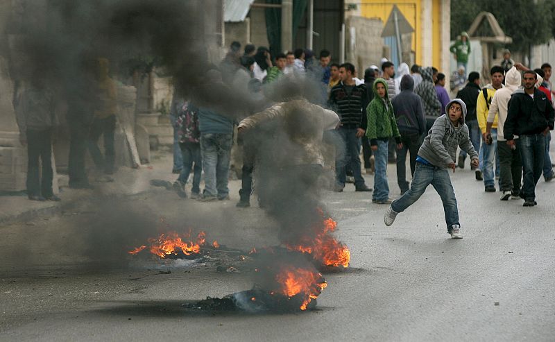 Varios palestinos tiran piedras al ejército israelí en el paso de Kalandia, que separa Cisjordania de Jerusalén