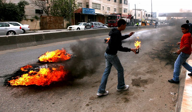 Un palestino se dispone a lanzar una bomba inciendaria contra los soldados israelíes en el paso de Kalandia