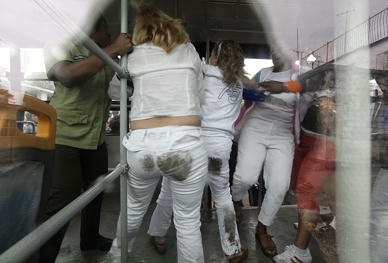 Security forces lead members of the Ladies in Whiteinto a bus after a march in Havana