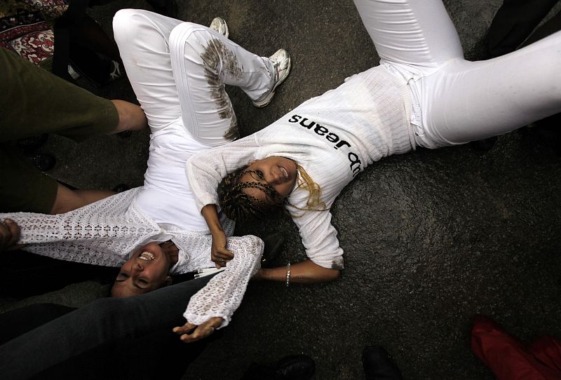 Security forces drag members of the Ladies in White into a bus after a march in Havana