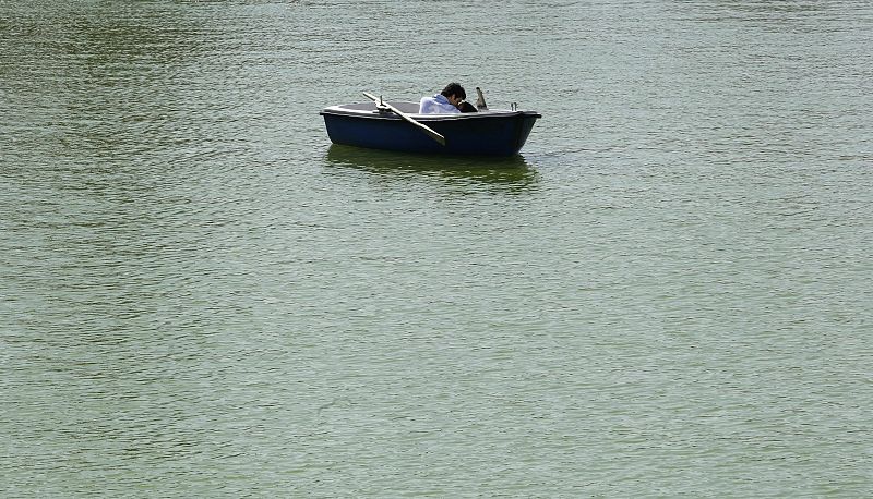 A couple kisses on a boat in a lake at Madrid's Retiro park on a warm morning just a few days before the start of spring