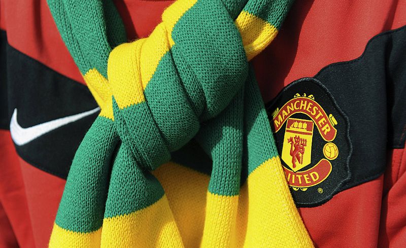 Un aficionado del United lleva una bufanda verde y dorada, los colores originarios del Manchester, en señal de protesta contra los propietarios, los hermanos Glazer.