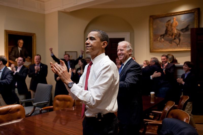 Obama, Biden y los asesores del presidente aplauden en la sala Roosevelt al conocer el resultado de la votación del Congreso.