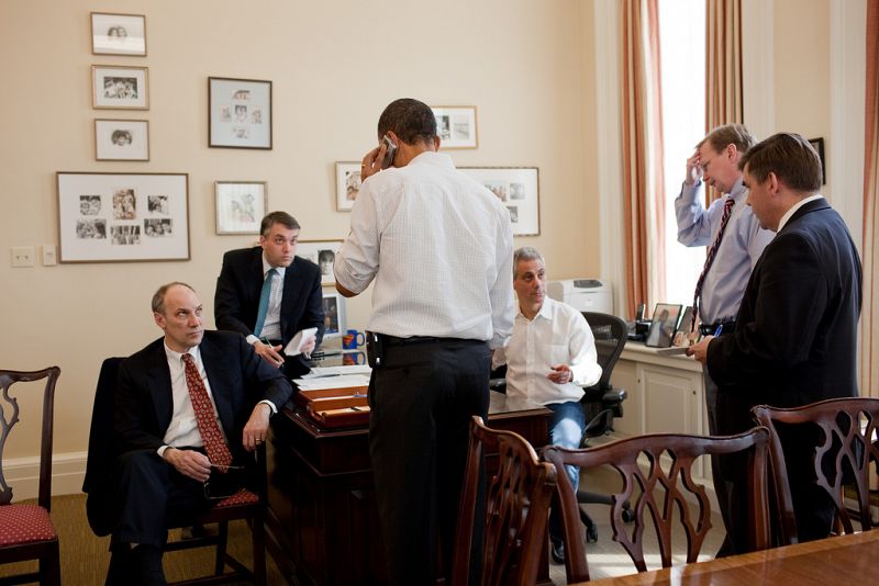 Los asesores de Obama, entre ellos su jefe de gabinete, Rahm Emanuel, asisten a la conversación telefónica de Obama con un miembro del Congreso en el despacho de Emanuel.