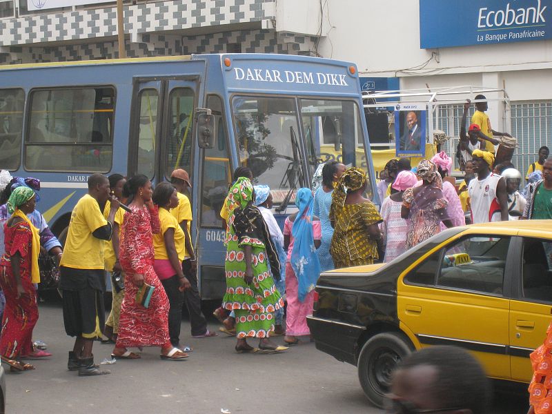 Ciudadanos senegaleses cruzando la calle en medio del tráfico.