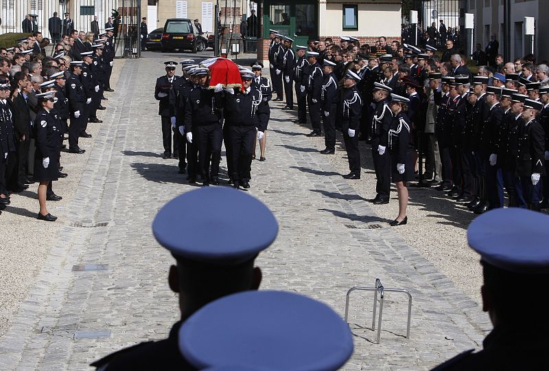 Colleagues carry the flag-drapped coffin of slain police officer Nerin during cermony in Melin