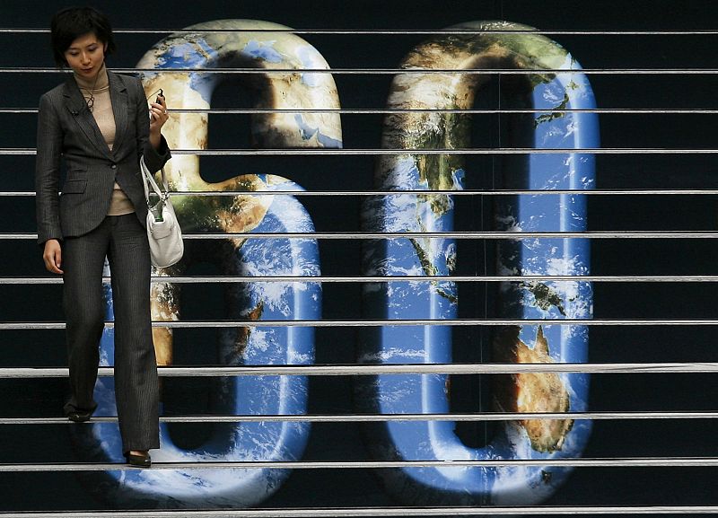 A woman walks down the stairs outside a bank at Hong Kong's financial district promoting the upcoming Earth Hour event