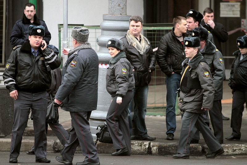 A fire-fighter and Interior Ministry officers work near the entrance of the Lubyanka metro station in Moscow