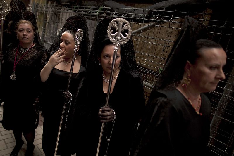 Women wearing traditional mantilla dresses take part in a procession of the Gitanos brotherhood during Holy Week in the Andalusian city of Malaga