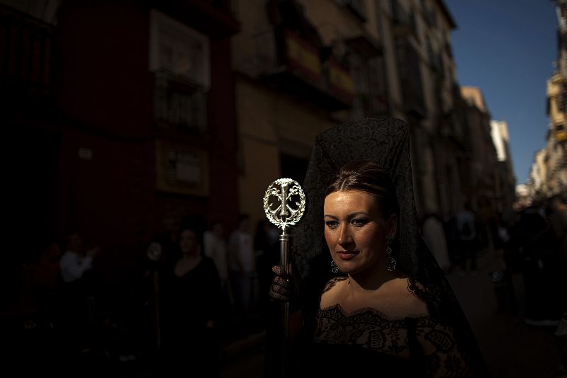 A woman wearing a traditional mantilla dress takes part in a procession of the Gitanos brotherhood during Holy Week in the Andalusian city of Malaga