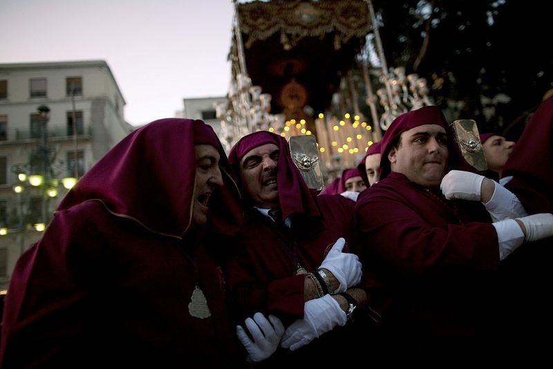 A foreman helps a penitent as he carries the statue of the Virgin of the Gitanos brotherhood during Holy Week in the Andalusian city of Malaga