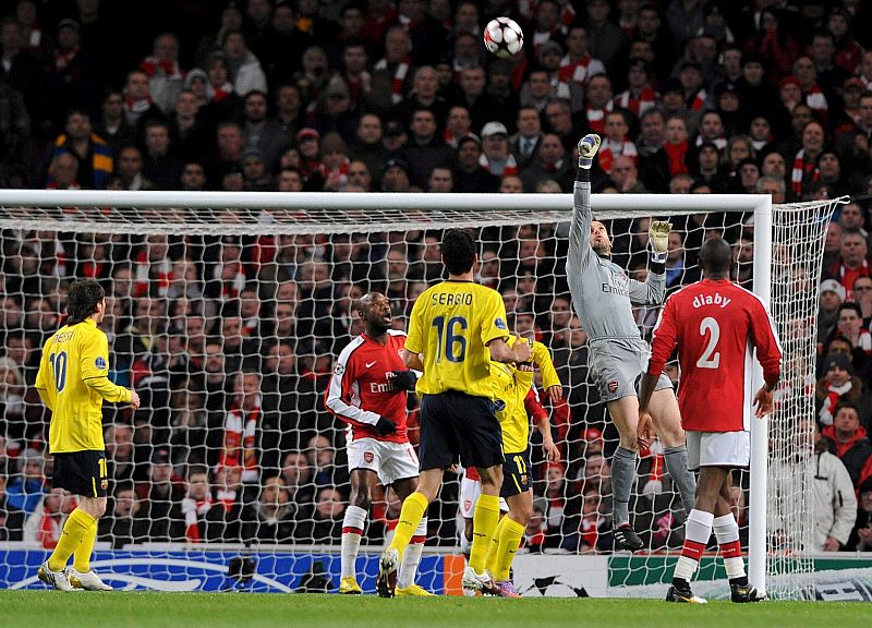 El portero español del Arsenal, Manuel Almunia, despeja un balón con el puño tras un tiro a puerta del FC Barcelona.