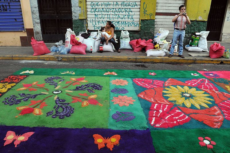 Ciudadanos hondureños elaboran alfombras de aserrín de madera tinturado con diversos diseños sobre una de las calles de Tegucigalpa (Honduras), como parte de los eventos de celebración de la Semana Santa en la capital.