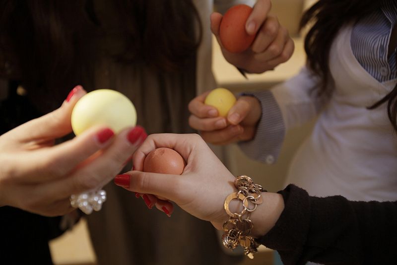 Lebanese Christian women break their painted eggs in celebration of Easter after an Easter service at St. George church in central Beirut