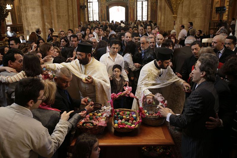 Lebanese Christian priests distribute painted eggs in celebration of Easter after an Easter service at St. George church in central Beirut