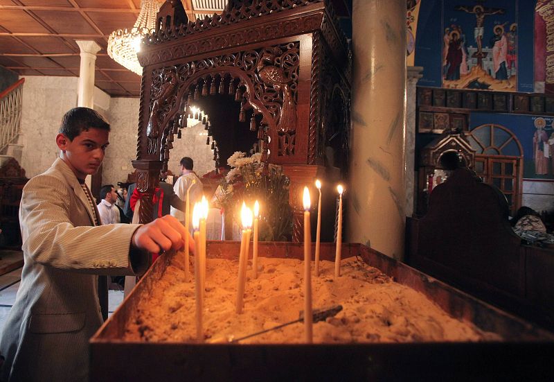 Palestinian Christian lights a candle during an Easter mass at al-Roum Church in Gaza