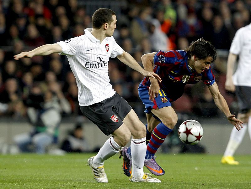 El delantero del FC Barcelona, Bojan Krkic y el defensa belga del Arsenal, Thomas Vermaelen luchan por el balón.