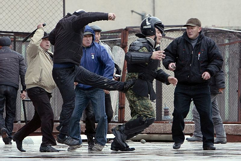 Un manifestante patea a un policía durante los disturbios que se han producido cerca del palacio presidencial en Biskek.