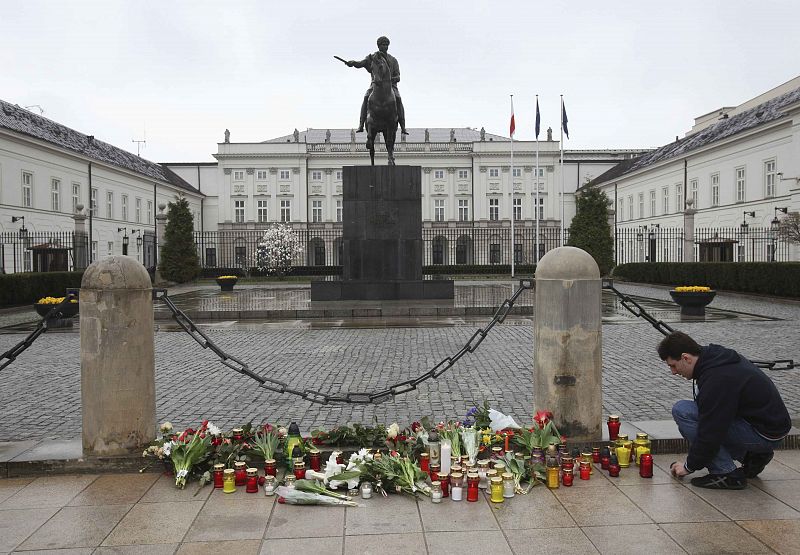 A man lights a candles in front of the Presidential Palace in Warsaw