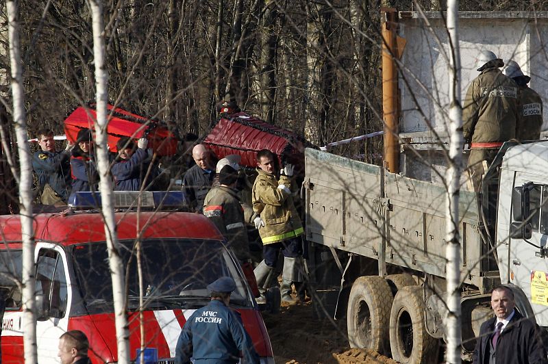 Emergencies Ministry members carry coffins with remains of the victims of a Polish government Tupolev Tu-154 aircraft crash and load them into a truck in Smolensk