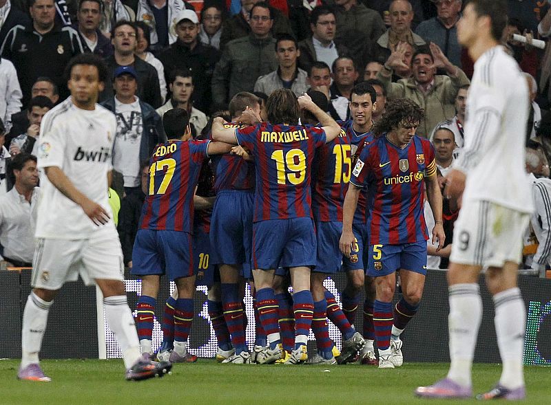 Los jugadores del FC Barcelona celebran el gol del delantero argentino Lionel Messi ante la decepción de los jugadores del Real Madrid.