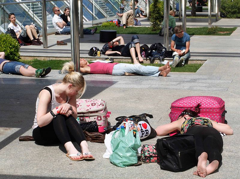 Más suerte tienen los pasajeros que se encuentran atrapados en el aeropuerto de Mallorca, que esperan que se reanuden los vuelos tomando el sol.