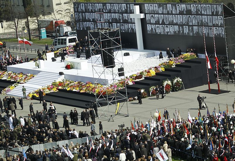 People wait for the start of a commemoration service for late Polish President Lech Kaczynski and other plane crash victims at the Pilsudski square in Warsaw