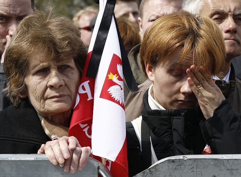 People react during commemoration ceremony for victims of plane crash in Smolensk at Pilsudski square in Warsaw