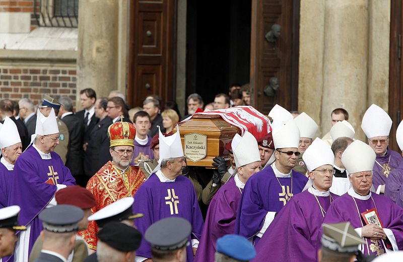 Catholic priests walk in front of Polish officers carrying coffin of late Polish President Kaczynski in front of Mariacki Church in Krakow