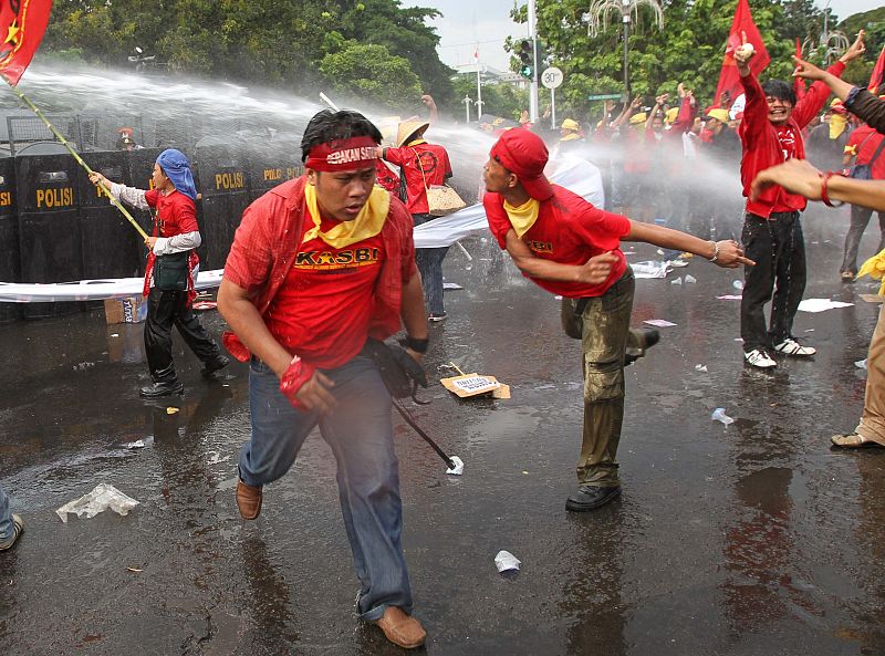 Police try to disperse members from the labour union Kasbi with water cannons during a protest on International Labour Day in front of the Presidential Palace in Jakarta