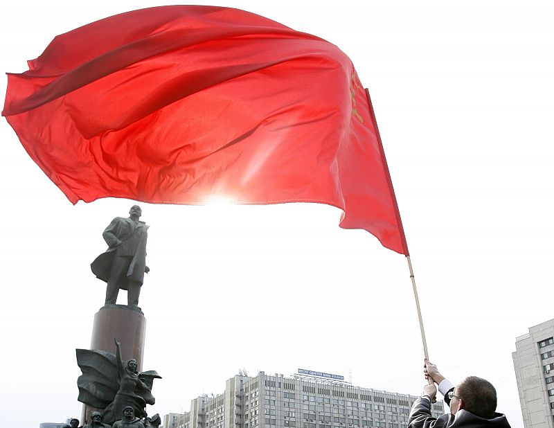 A communist waves the Soviet flag during a rally near the statue of Soviet state founder Lenin in Moscow