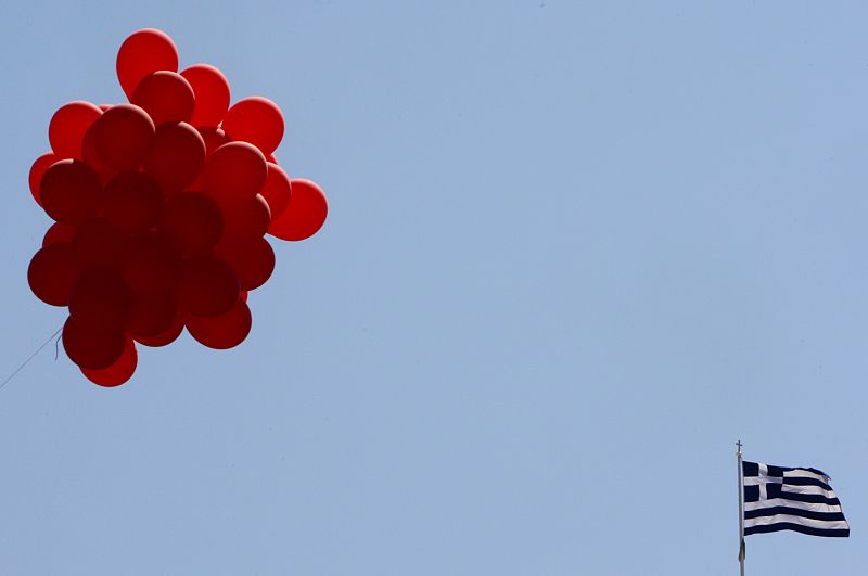 A Greek flag flutters next to balloons during a May Day rally at central Syntagma square in Athens