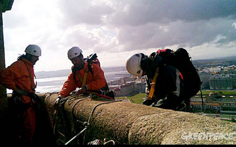 Desde la parte superior, tres escaladores han comenzado a colgarse por la fachada del faro romano.