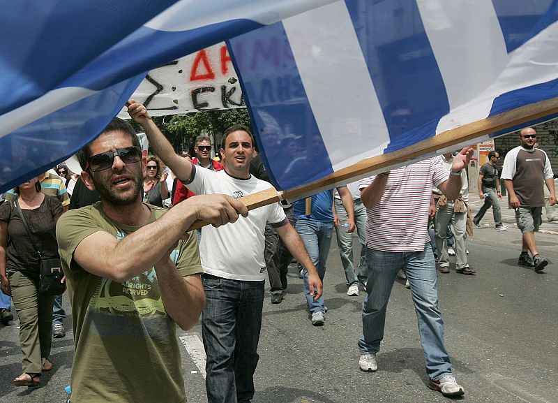 Un manifestante enarbola una bandera griega durante un acto de protesta frente al Parlamento griego.