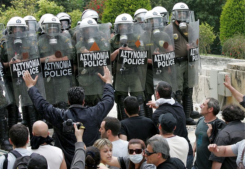 Unos manifestantes se enfrentan a unos agentes de la policía antidisturbios durante las protestas en la jornada de huelga este miércoles en Grecia.