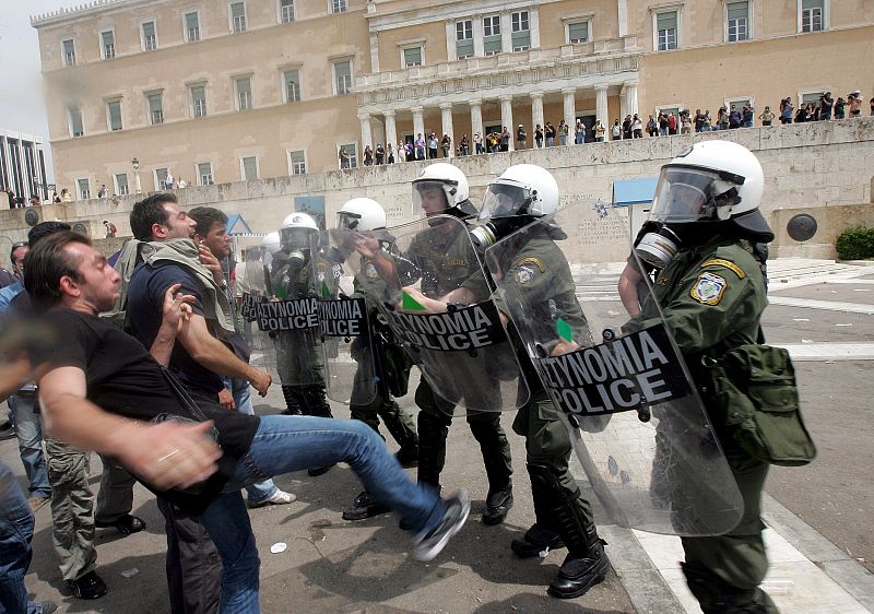 Unos manifestantes se enfrentan con la policía antidisturbios en Atenas.